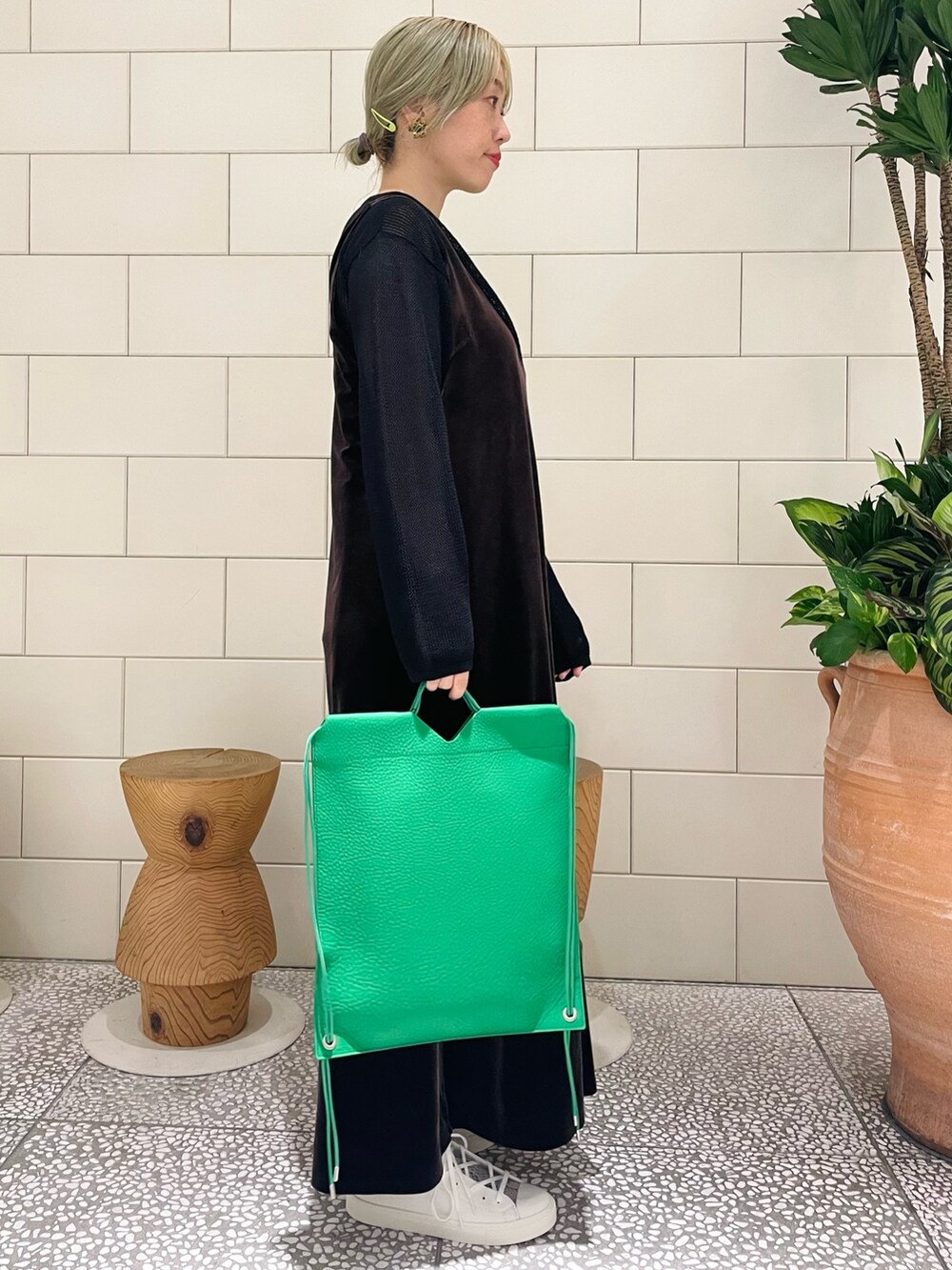 ブラウン系のワンピース、ブラック系のニット/セーター、ホワイト系のスニーカーを着用したレディースの夏コーディネートの2枚目の写真