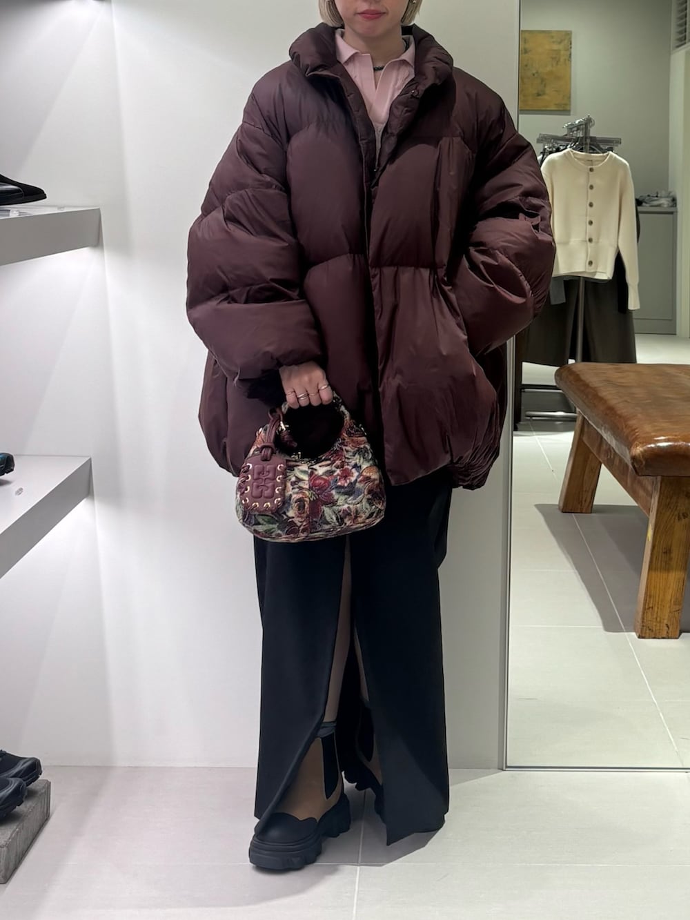 レッド系のダウンジャケット/コート、ピンク系のニット/セーター、ブラック系のスカートを着用したレディースの秋コーディネートの2枚目の写真