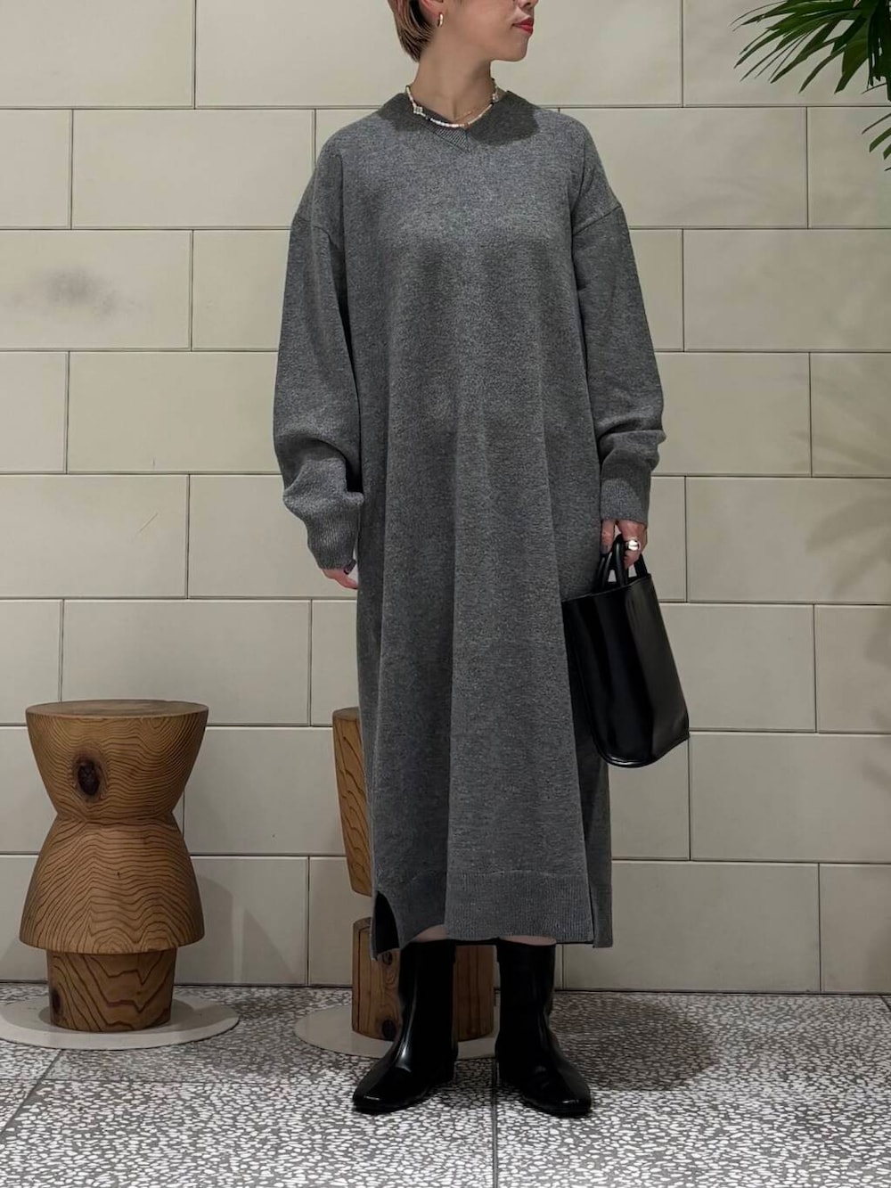 ブラック系のトートバッグ、ブラック系のブーツ、ホワイト系のダウンジャケット/コートを着用したレディースの冬コーディネートの2枚目の写真