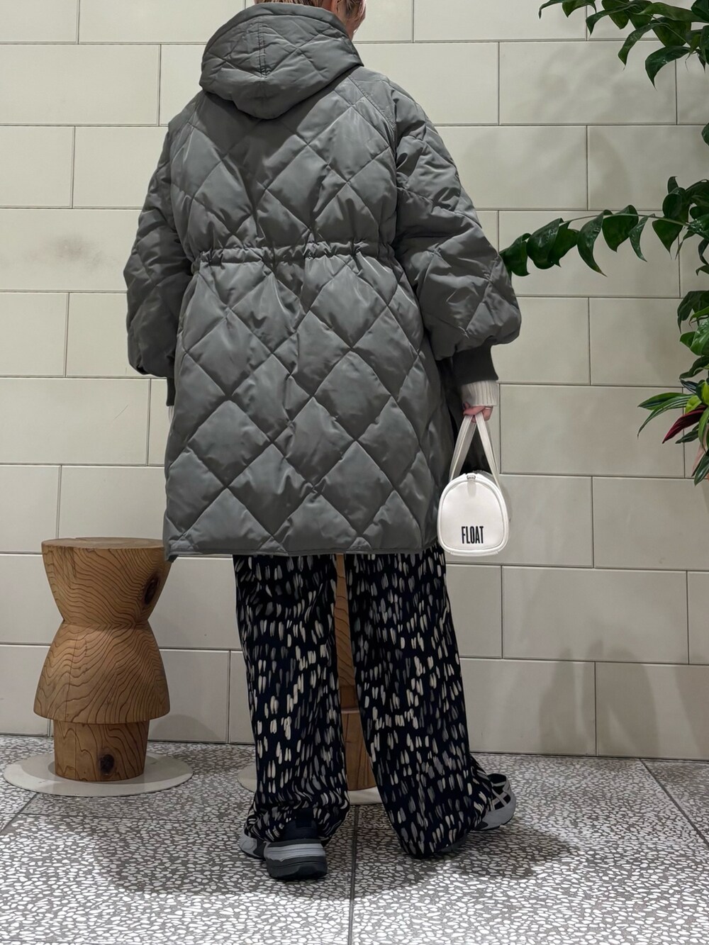 グレー系のダウンジャケット/コート、ベージュ系のニット/セーター、ブラック系のその他パンツを着用したレディースの冬コーディネートの2枚目の写真