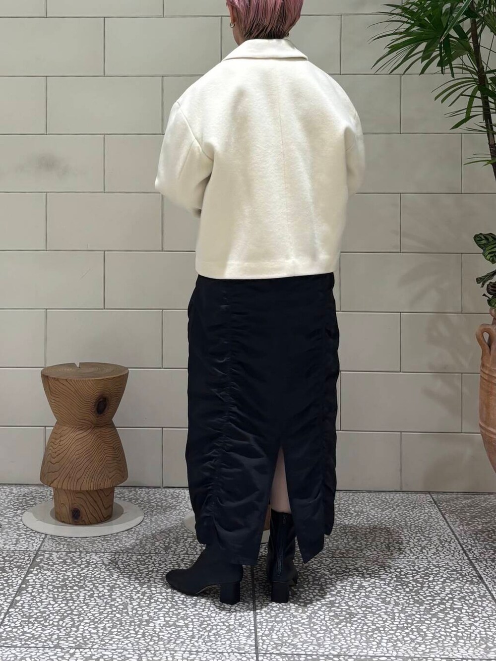 ブラック系のブーツ、ホワイト系のボストンバッグ、ブラック系のスカートを着用したレディースの冬コーディネートの4枚目の写真