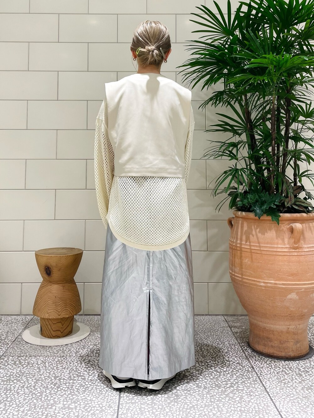 ホワイト系のベスト、ホワイト系のニット/セーター、シルバー系のスカートを着用したレディースの冬コーディネートの3枚目の写真