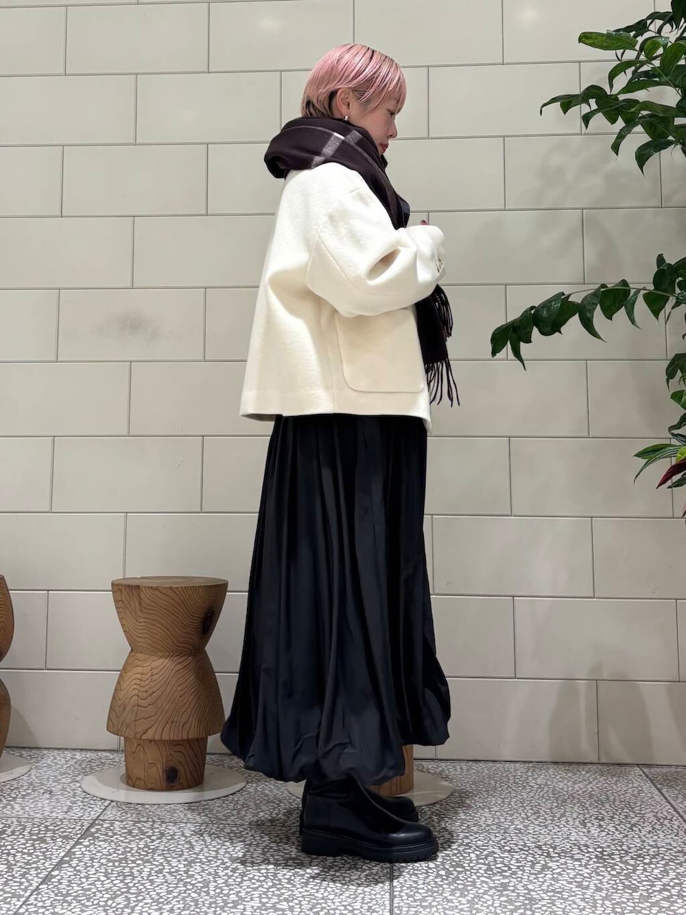 ブラック系のブーツ、ホワイト系のその他アウター、ブラック系のワンピースを着用したレディースの冬コーディネートの2枚目の写真