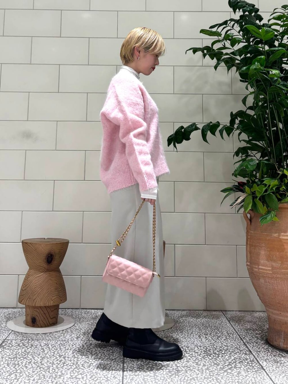 ピンク系のショルダーバッグ、ホワイト系のTシャツ/カットソー、ピンク系のニット/セーターを着用したレディースの秋コーディネートの2枚目の写真