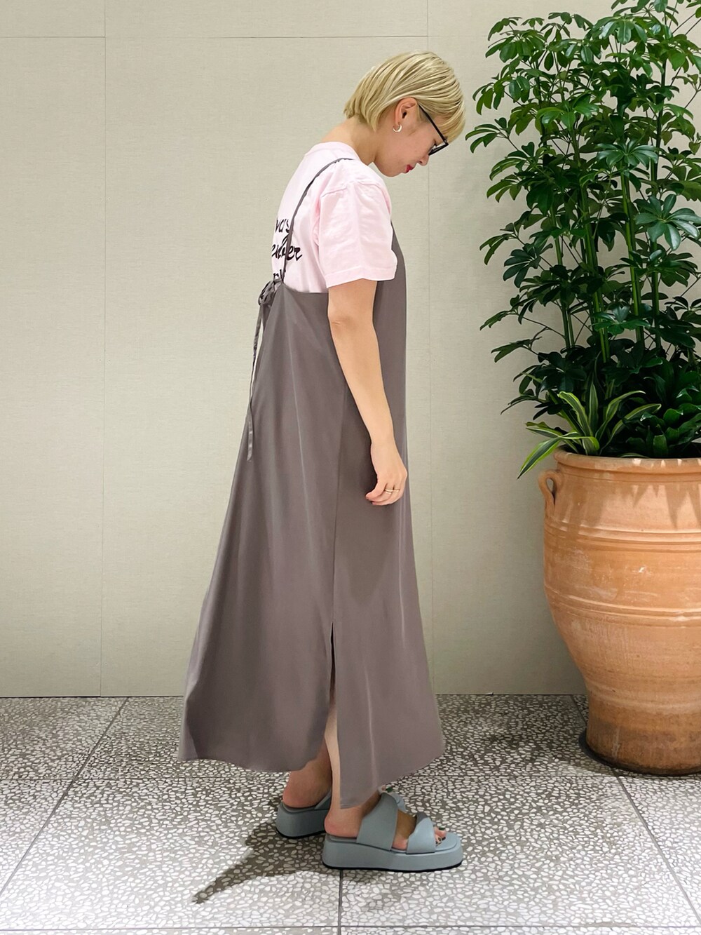 ピンク系のTシャツ/カットソー、ブラウン系のワンピース、ブルー系のサンダルを着用したレディースの春コーディネートの2枚目の写真