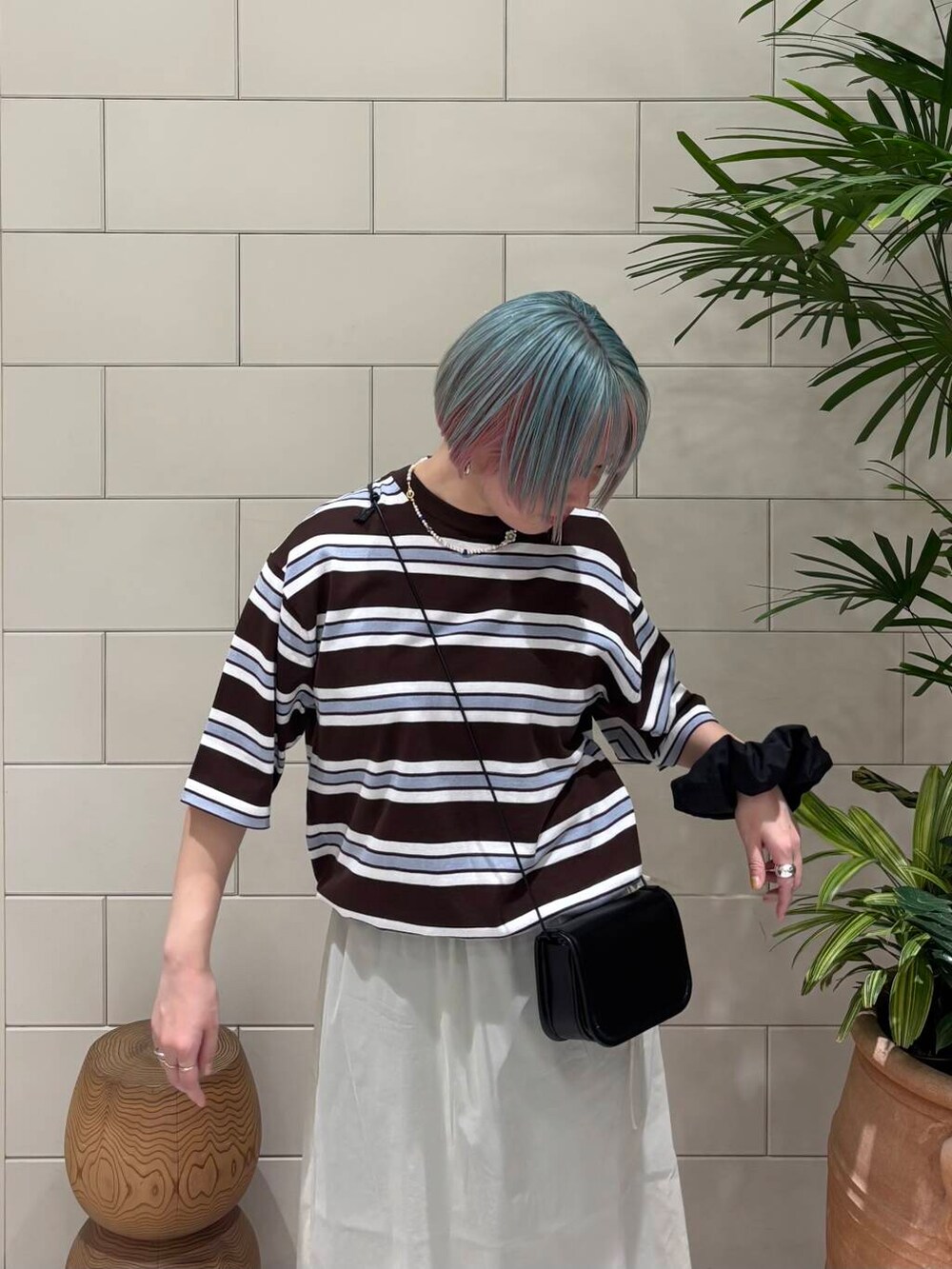 ブルー系のデニムパンツ、ブラック系のショルダーバッグ、ブラック系のパンプスを着用したレディースの春コーディネートの2枚目の写真