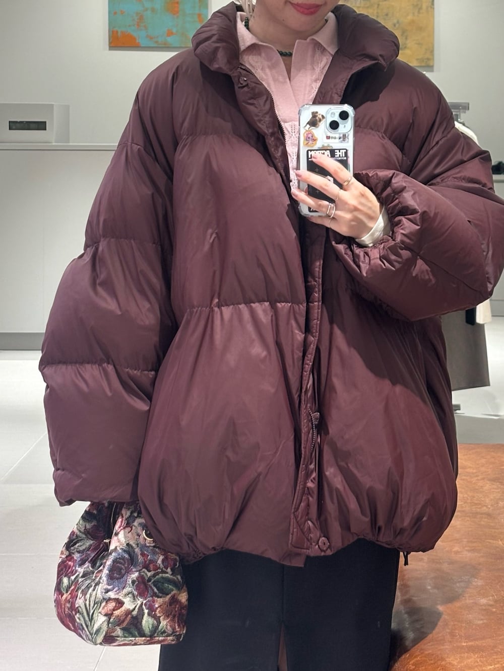 レッド系のダウンジャケット/コート、ピンク系のニット/セーター、ブラック系のスカートを着用したレディースの秋コーディネートの3枚目の写真