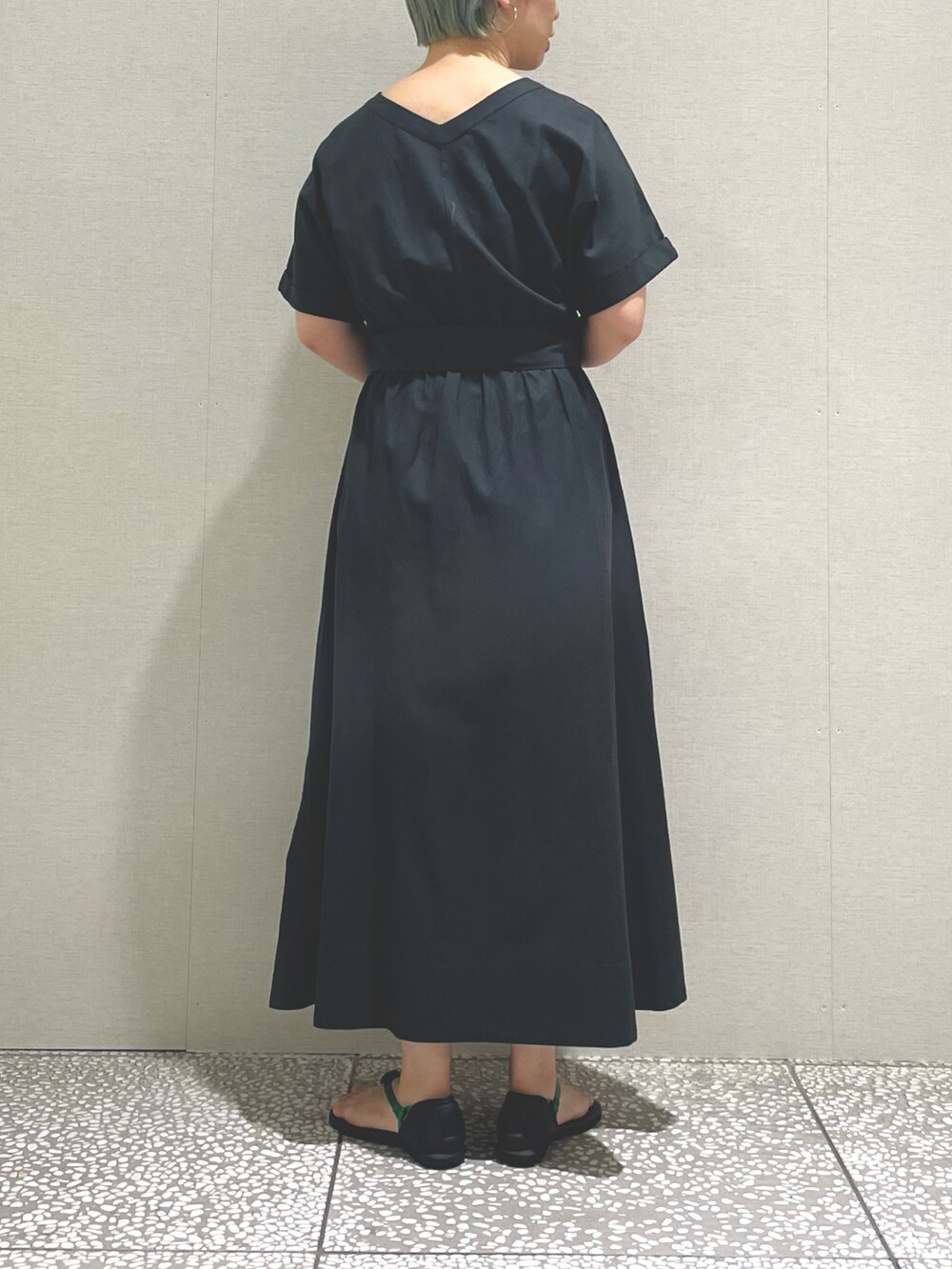 グレー系のワンピース、グリーン系のサンダル、シルバー系のピアス（両耳用）を着用したレディースの夏コーディネートの2枚目の写真