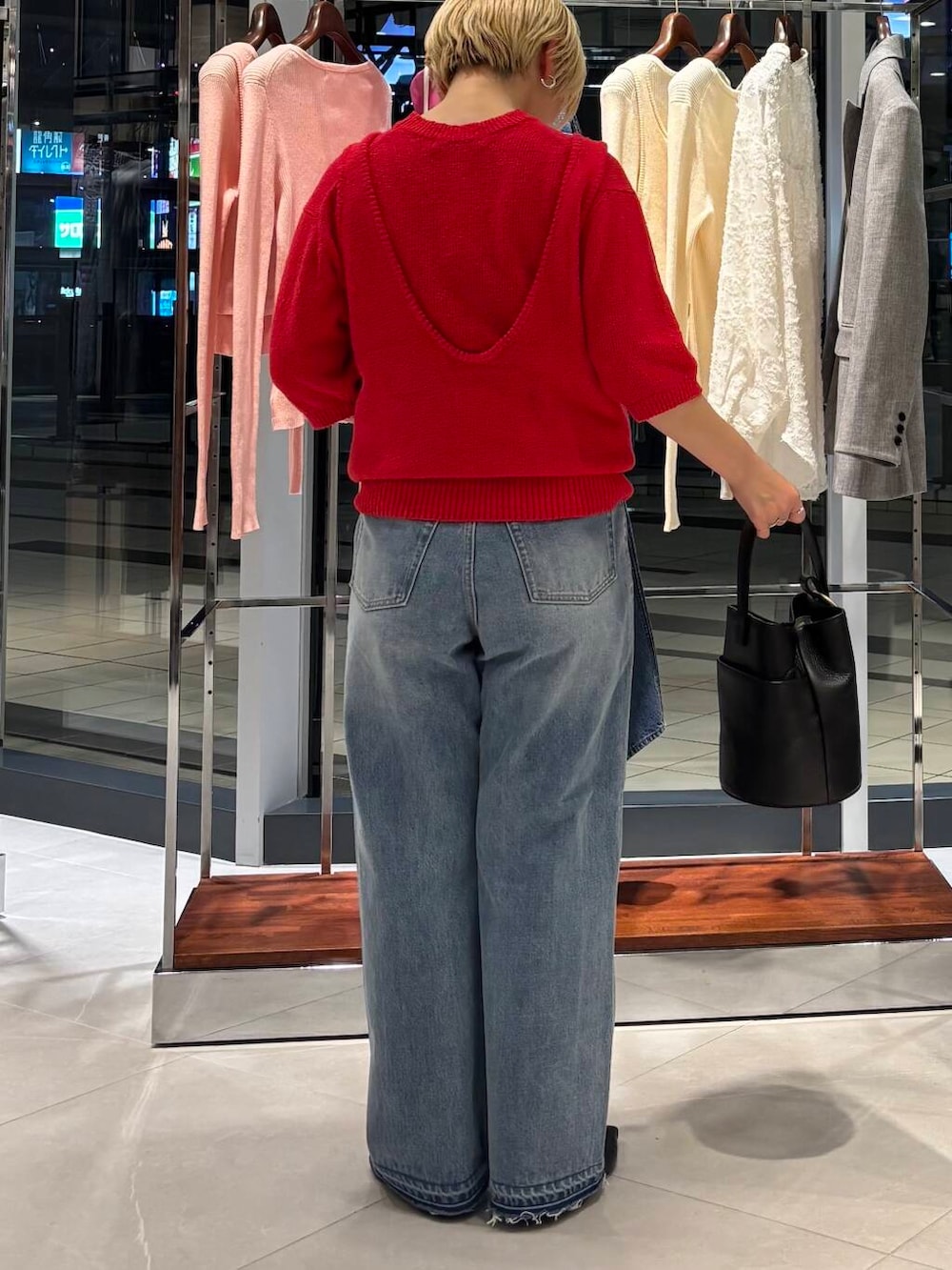 ブルー系のデニムパンツ、レッド系のベスト、レッド系のニット/セーターを着用したレディースの冬コーディネートの4枚目の写真