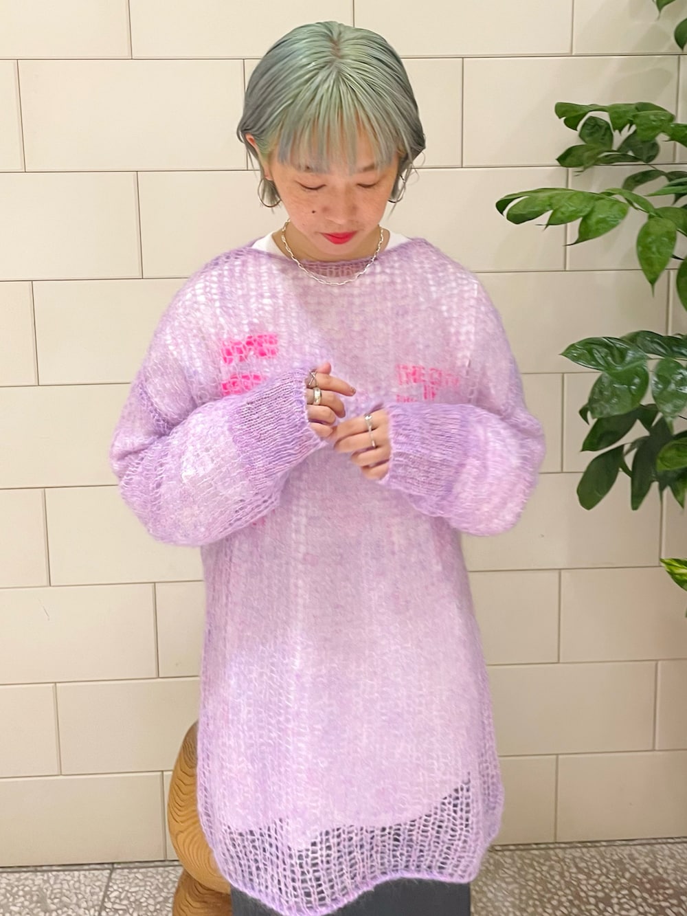 パープル系のニット/セーター、ホワイト系のTシャツ/カットソー、グレー系のスカートを着用したレディースの秋コーディネートの3枚目の写真