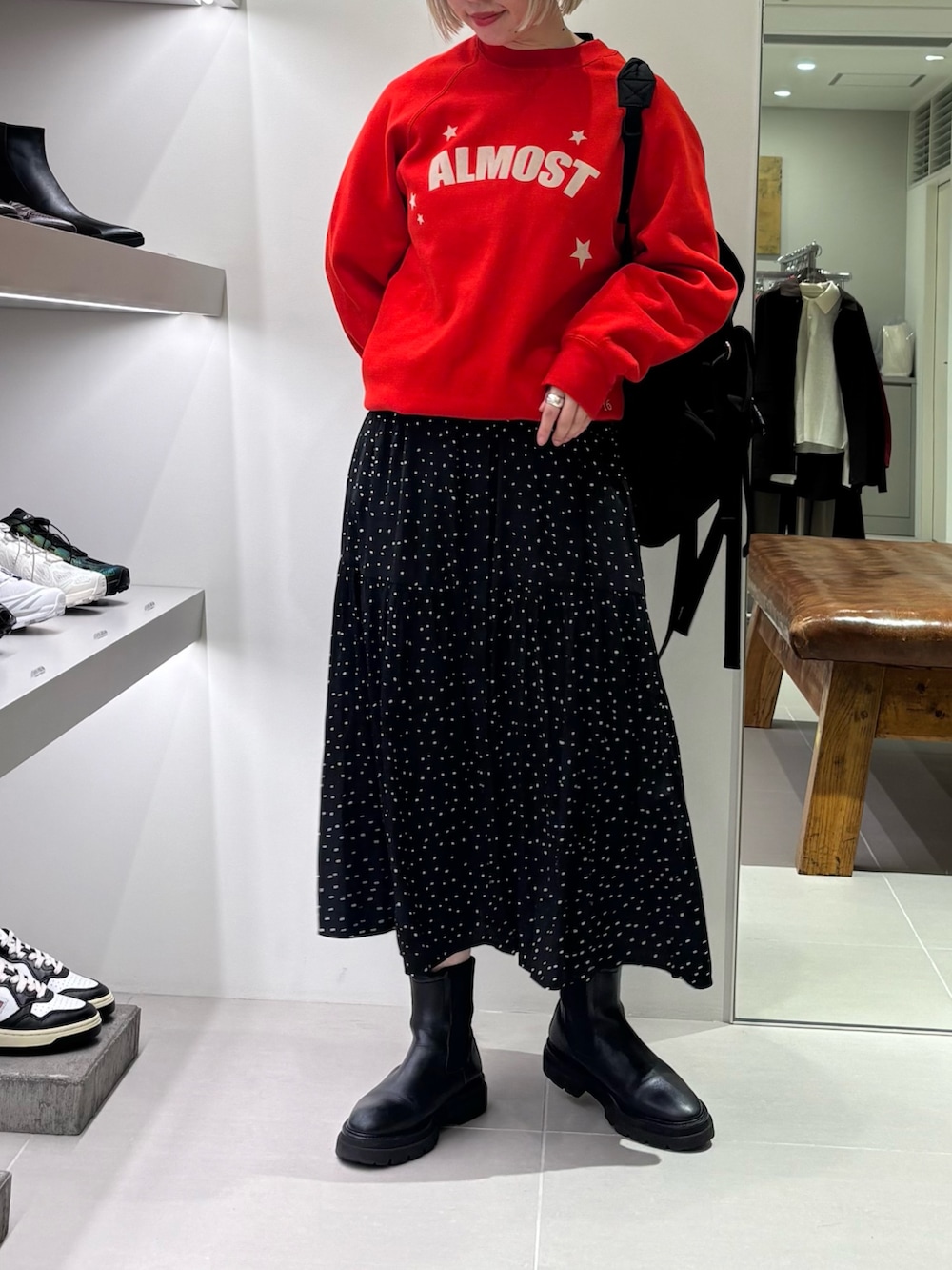 ブラック系のバックパック/リュック、ブラック系のワンピース、レッド系のスウェットを着用したレディースの秋コーディネートの2枚目の写真