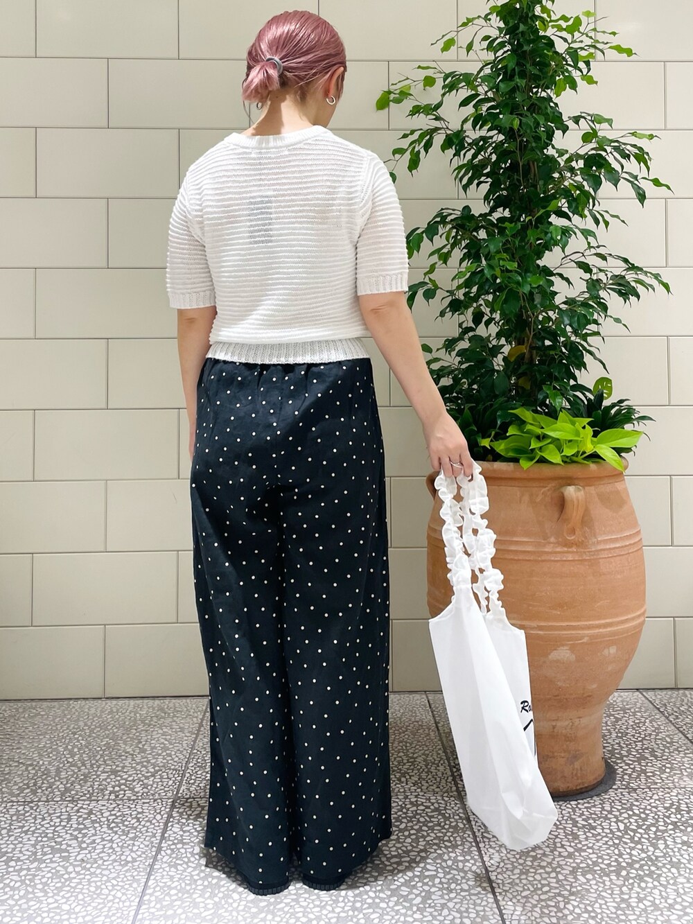 ホワイト系のニット/セーター、ブラック系のその他パンツ、ホワイト系のトートバッグを着用したレディースの春コーディネートの3枚目の写真