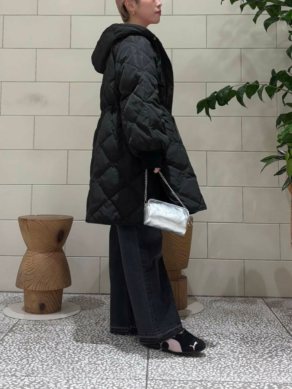 ブラック系のデニムパンツ、ピンク系のニット/セーター、シルバー系のショルダーバッグを着用したレディースの冬コーディネートの2枚目の写真