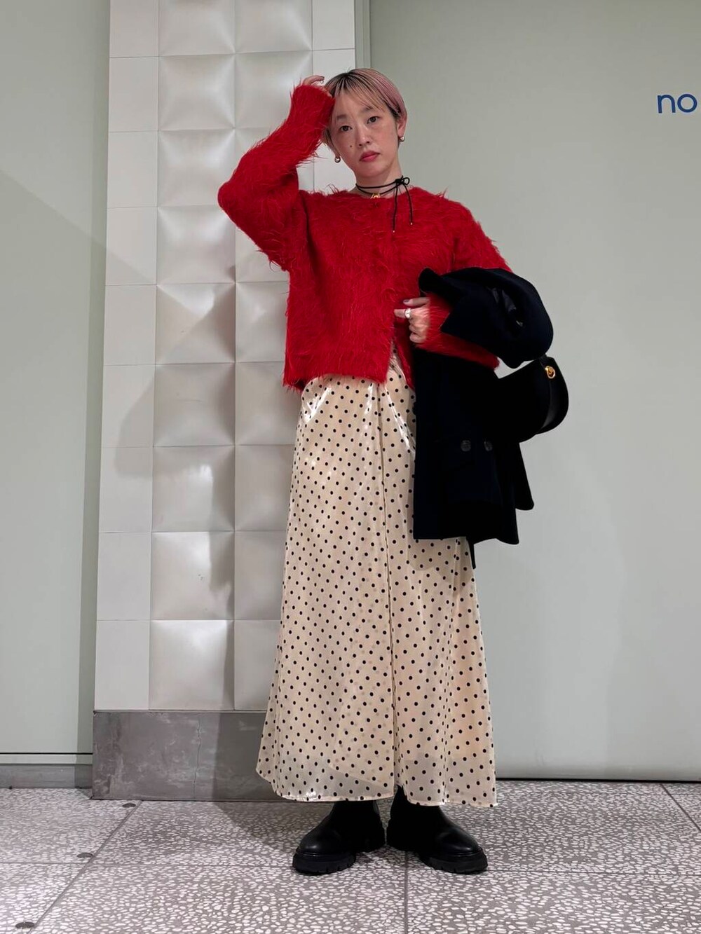 ブルー系のピーコート、レッド系のカーディガン/ボレロ、ベージュ系のスカートを着用したレディースの冬コーディネートの4枚目の写真