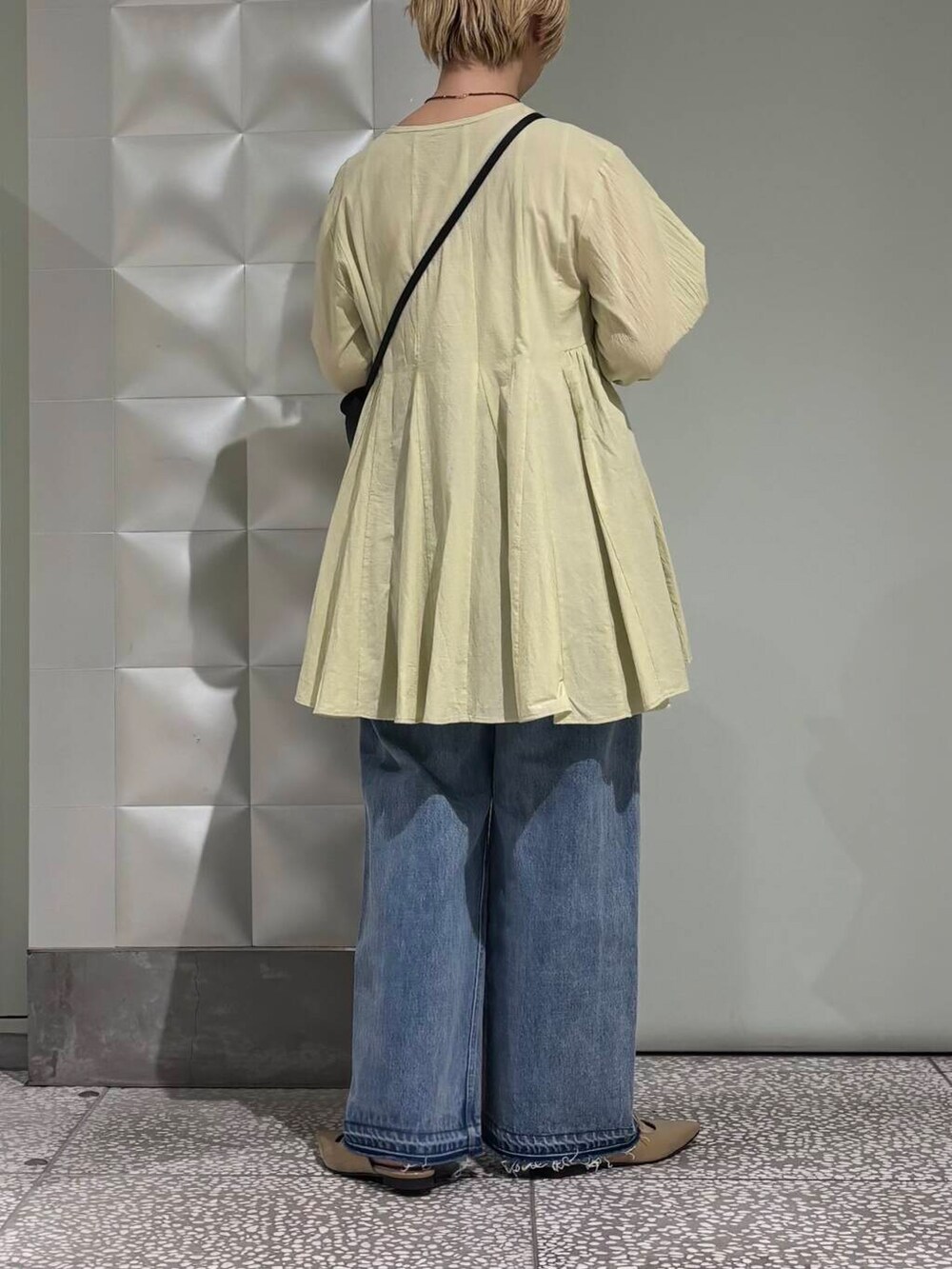 ブルー系のデニムパンツ、ベージュ系のパンプス、グリーン系のシャツ/ブラウスを着用したレディースの春コーディネートの3枚目の写真