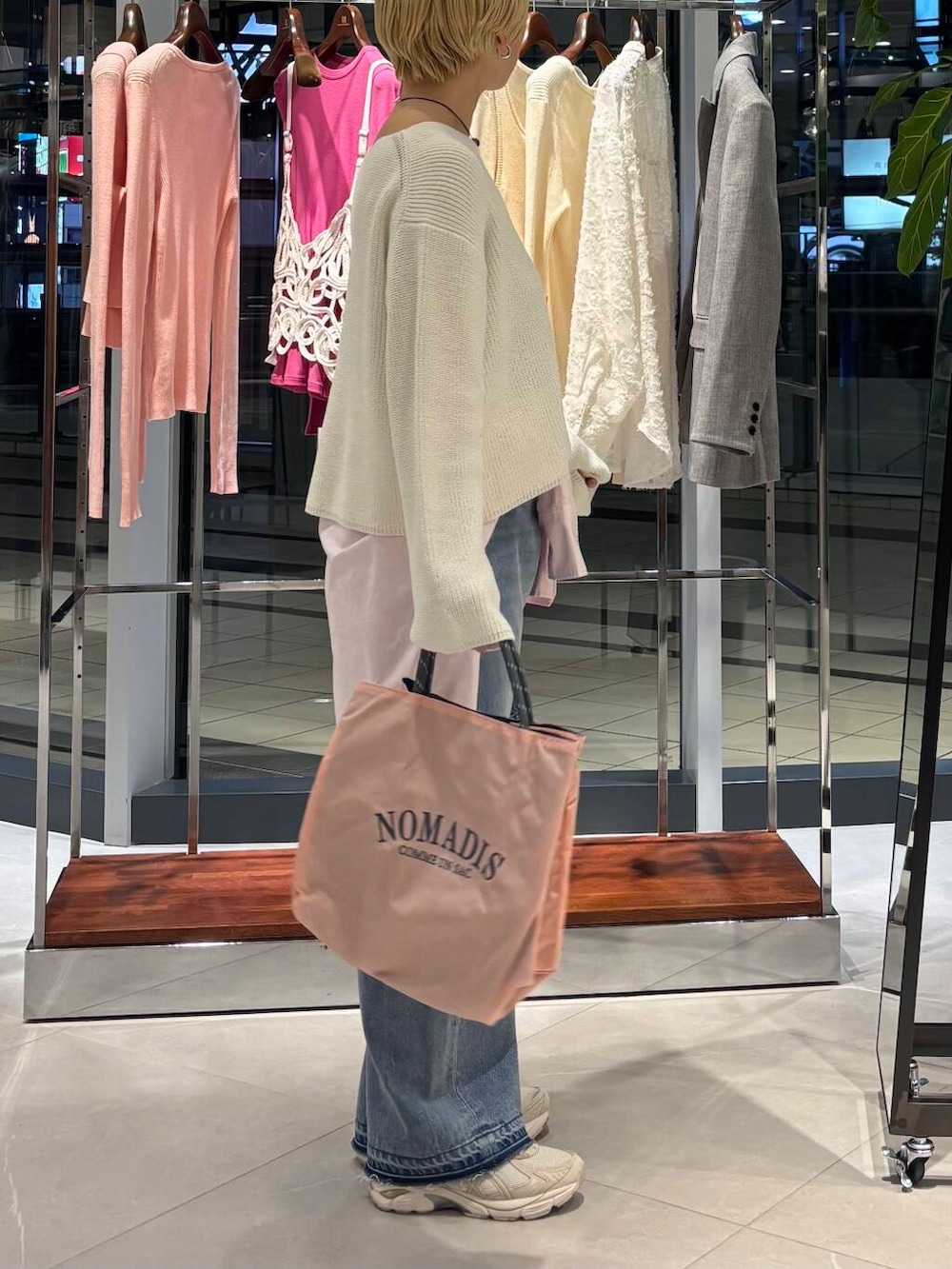 ブルー系のデニムパンツ、ピンク系のシャツ/ブラウス、ホワイト系のニット/セーターを着用したレディースの冬コーディネートの2枚目の写真