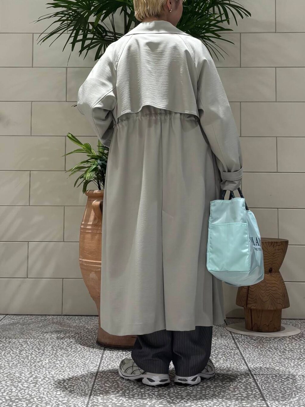 グレー系のその他パンツ、グリーン系のトレンチコート、グレー系のニット/セーターを着用したレディースの冬コーディネートの4枚目の写真