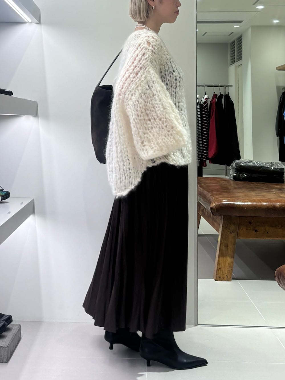 ホワイト系のニット/セーター、ブラウン系のトートバッグ、ブラウン系のスカートを着用したレディースの秋コーディネートの2枚目の写真