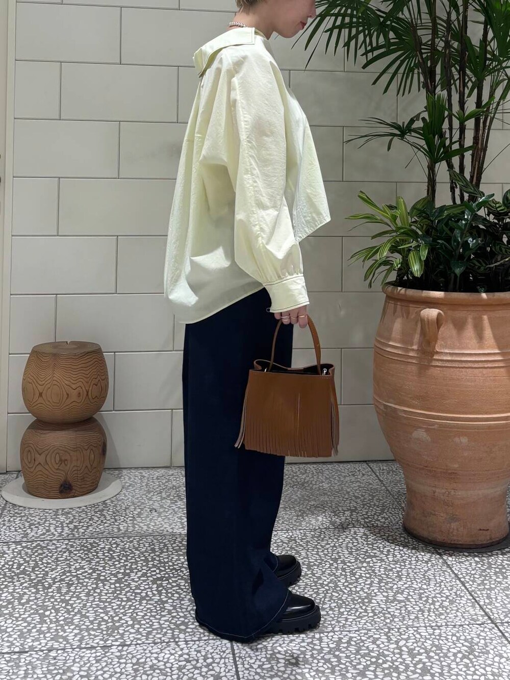 ブルー系のデニムパンツ、イエロー系のハンドバッグ、グリーン系のシャツ/ブラウスを着用したレディースの冬コーディネートの2枚目の写真