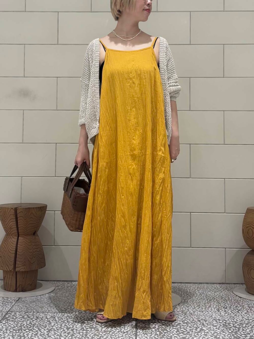 ホワイト系のカーディガン/ボレロ、ベージュ系のサンダル、イエロー系のワンピースを着用したレディースの春コーディネートの3枚目の写真