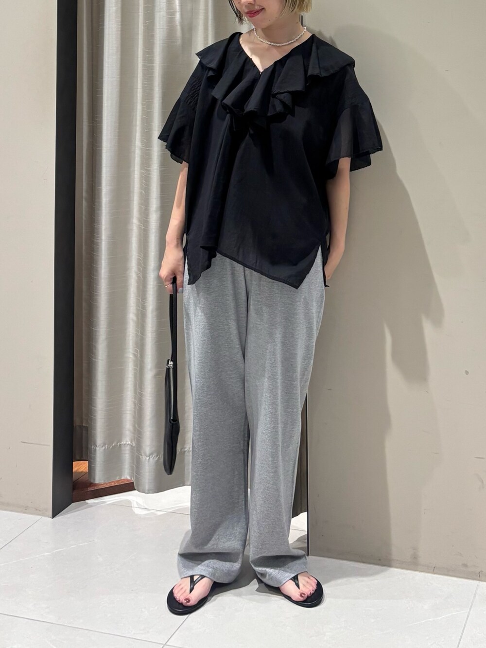 ブラック系のシャツ/ブラウス、グレー系のその他パンツ、ブラック系のサンダルを着用したレディースの夏コーディネートの2枚目の写真