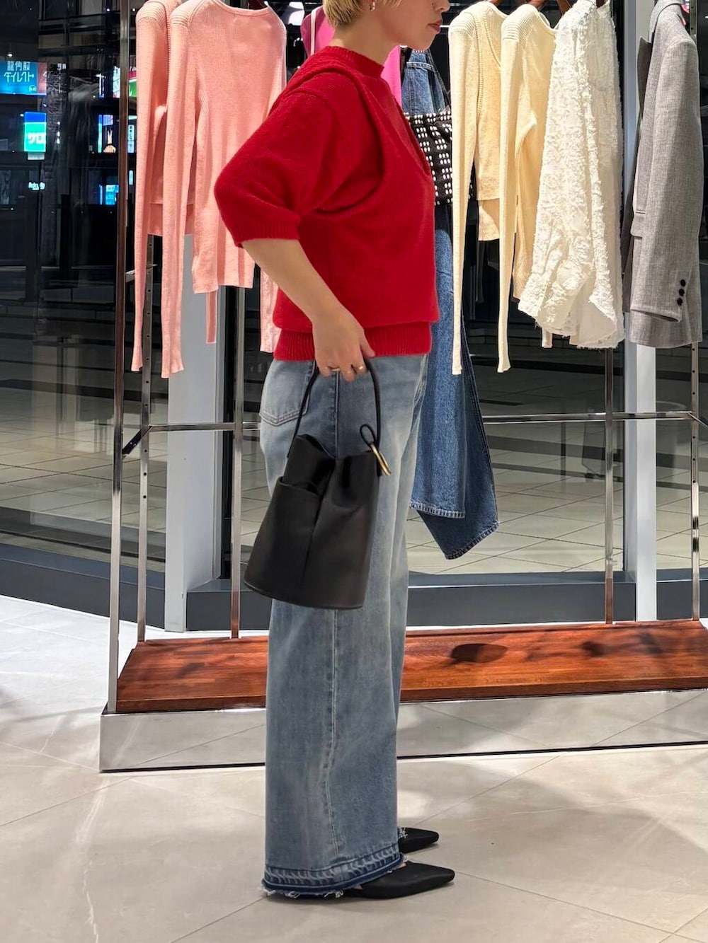 ブルー系のデニムパンツ、レッド系のベスト、レッド系のニット/セーターを着用したレディースの冬コーディネートの3枚目の写真
