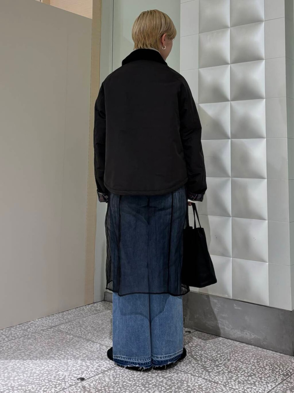 ブラック系のニット/セーター、ブルー系のデニムパンツ、ブラック系のその他アウターを着用したレディースの秋コーディネートの2枚目の写真