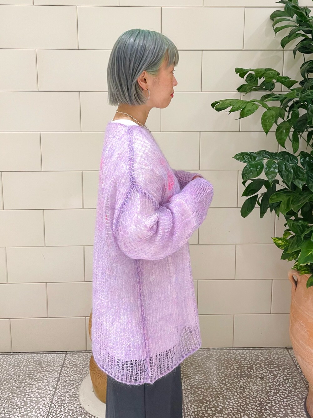 パープル系のニット/セーター、ホワイト系のTシャツ/カットソー、グレー系のスカートを着用したレディースの秋コーディネートの4枚目の写真