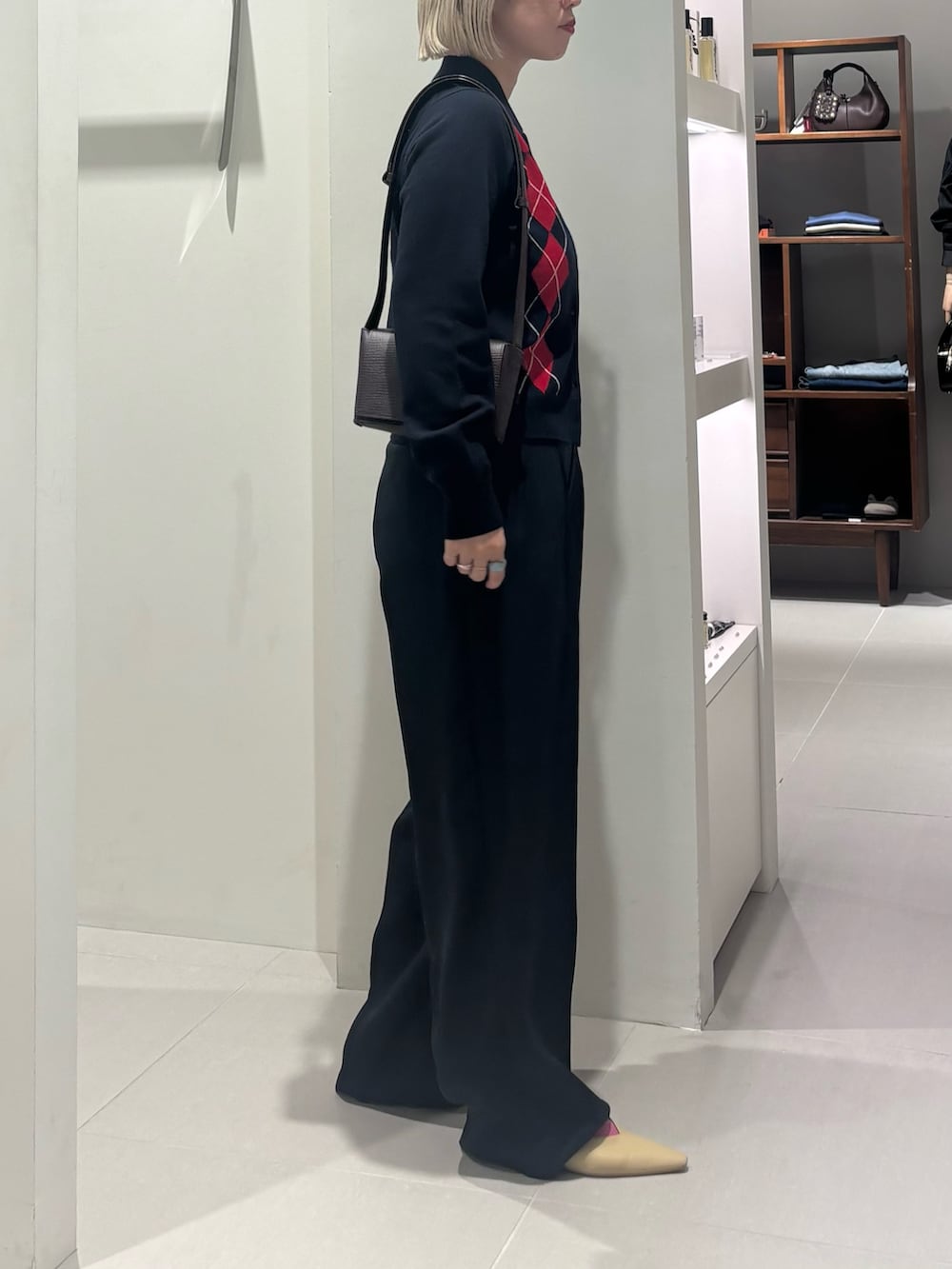 ブルー系のニット/セーター、ブラウン系のハンドバッグ、ブラック系のその他パンツを着用したレディースの秋コーディネートの2枚目の写真