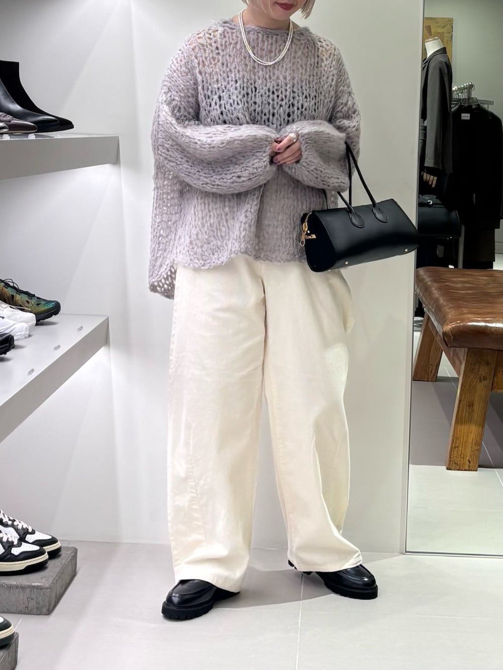 グレー系のニット/セーター、ホワイト系のその他パンツ、ブラック系のショルダーバッグを着用したレディースの秋コーディネートの2枚目の写真