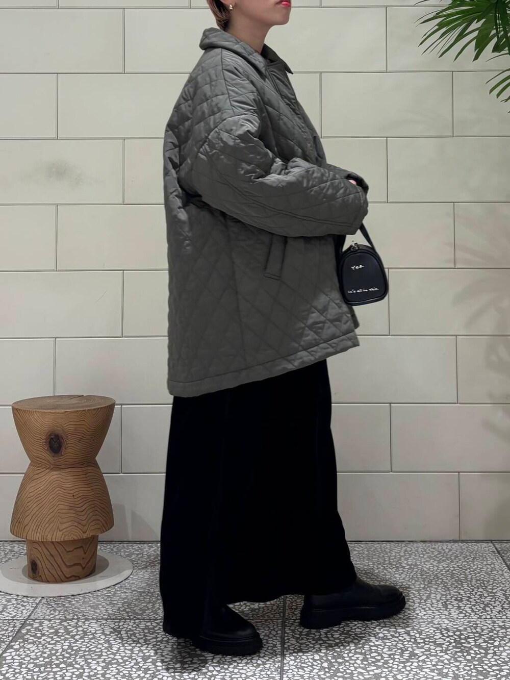 ブラック系のボストンバッグ、レッド系のニット/セーター、ブラック系のスカートを着用したレディースの冬コーディネートの2枚目の写真