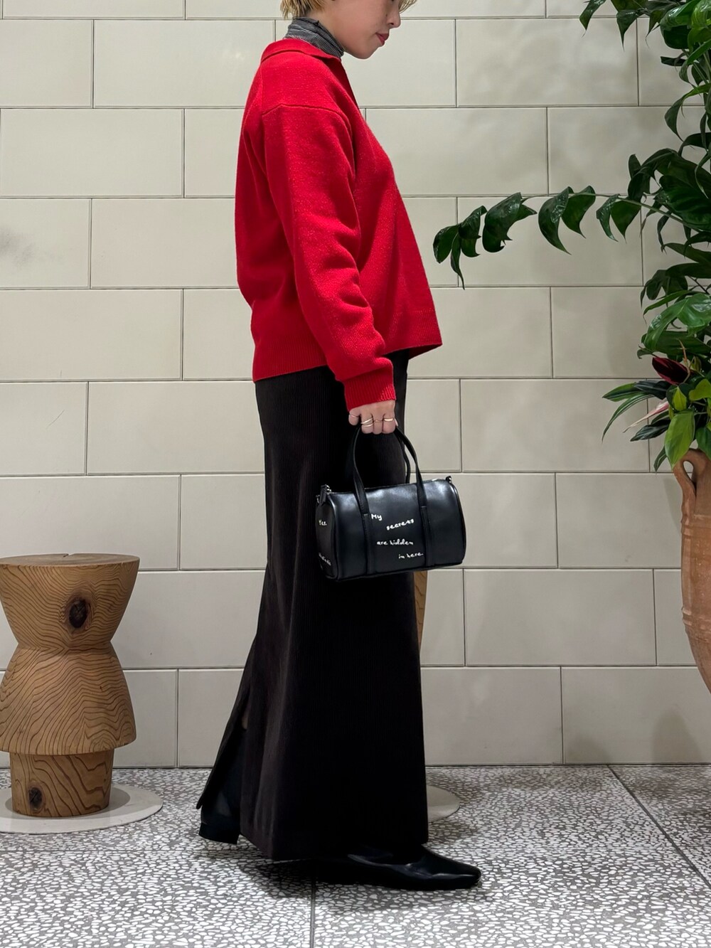 ブラック系のTシャツ/カットソー、ブラック系のブーツ、ブラック系のボストンバッグを着用したレディースの秋コーディネートの2枚目の写真