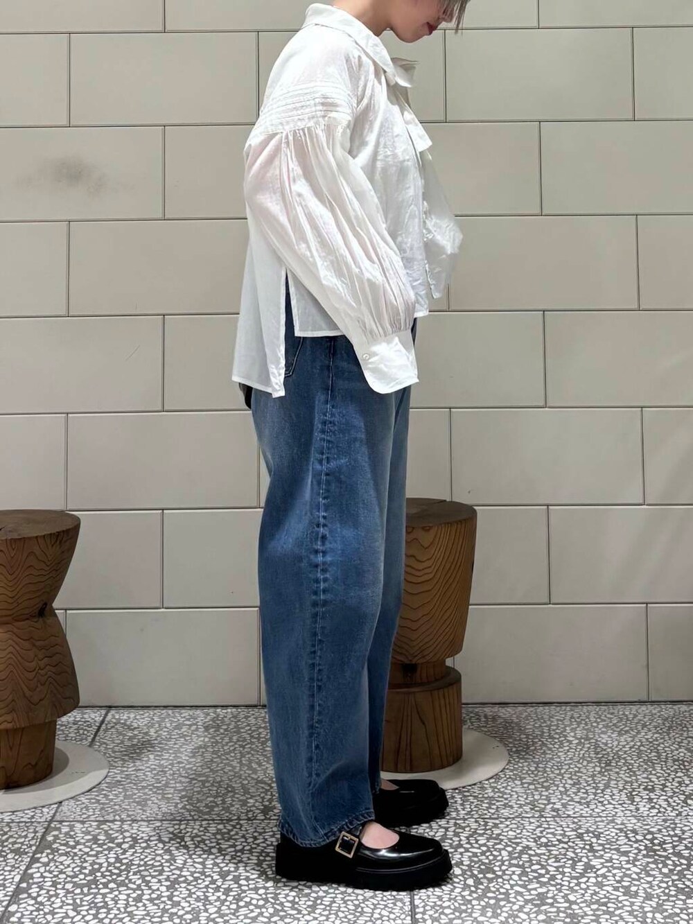 ブルー系のデニムパンツ、ブラック系のショルダーバッグ、ホワイト系のシャツ/ブラウスを着用したレディースの春コーディネートの3枚目の写真