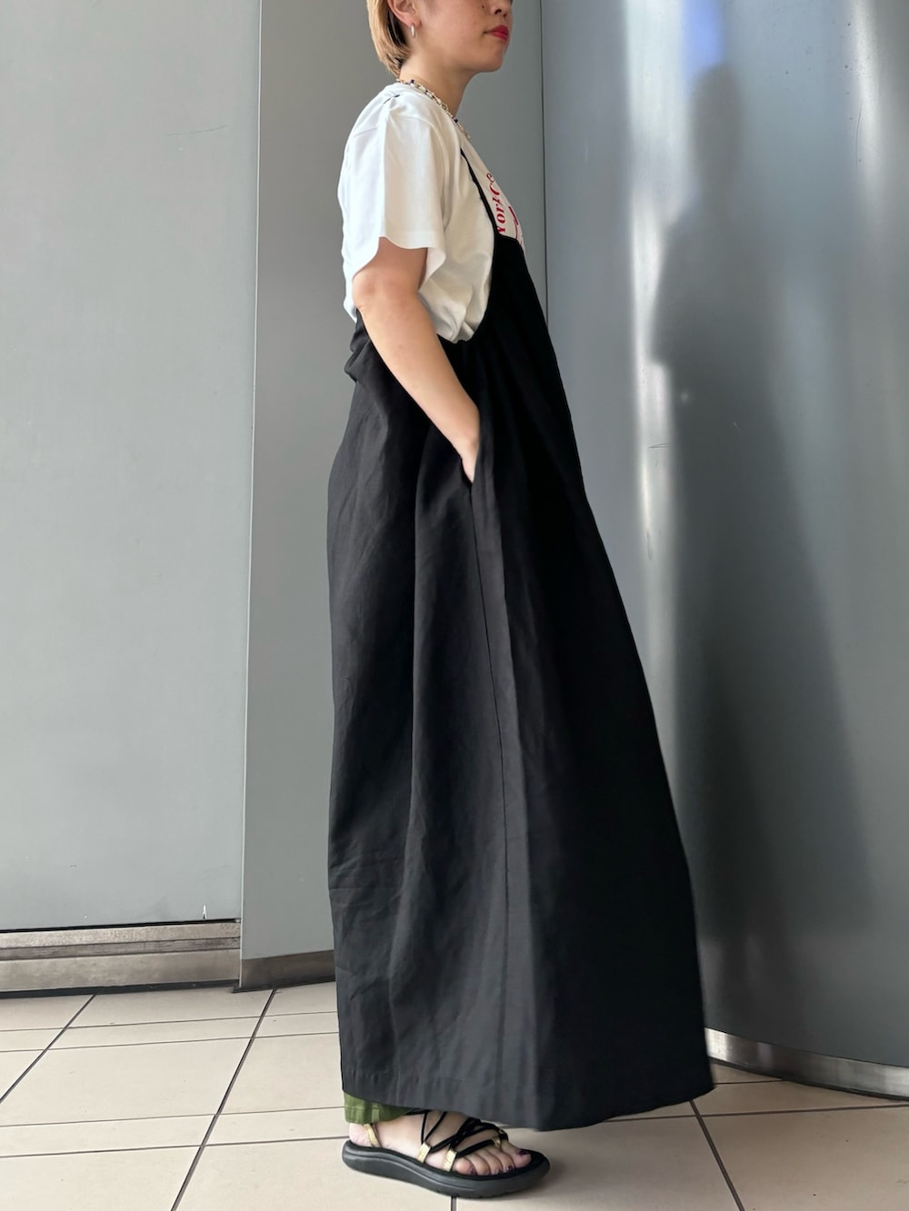 ブラック系のワンピース、ホワイト系のTシャツ/カットソー、グリーン系のパンツを着用したレディースの春コーディネートの3枚目の写真