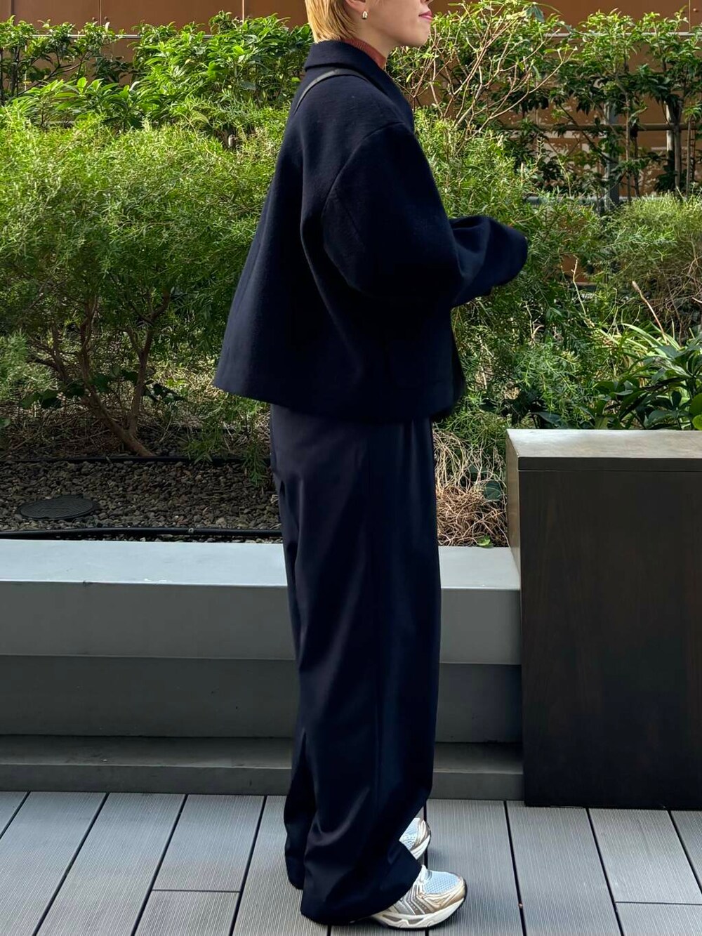 ホワイト系のスニーカー、オレンジ系のニット/セーター、ブルー系のその他パンツを着用したレディースの秋コーディネートの2枚目の写真