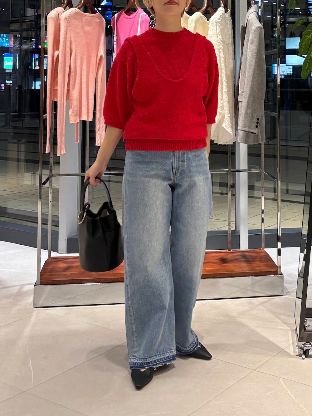 ブルー系のデニムパンツ、レッド系のベスト、レッド系のニット/セーターを着用したレディースの冬コーディネートの2枚目の写真