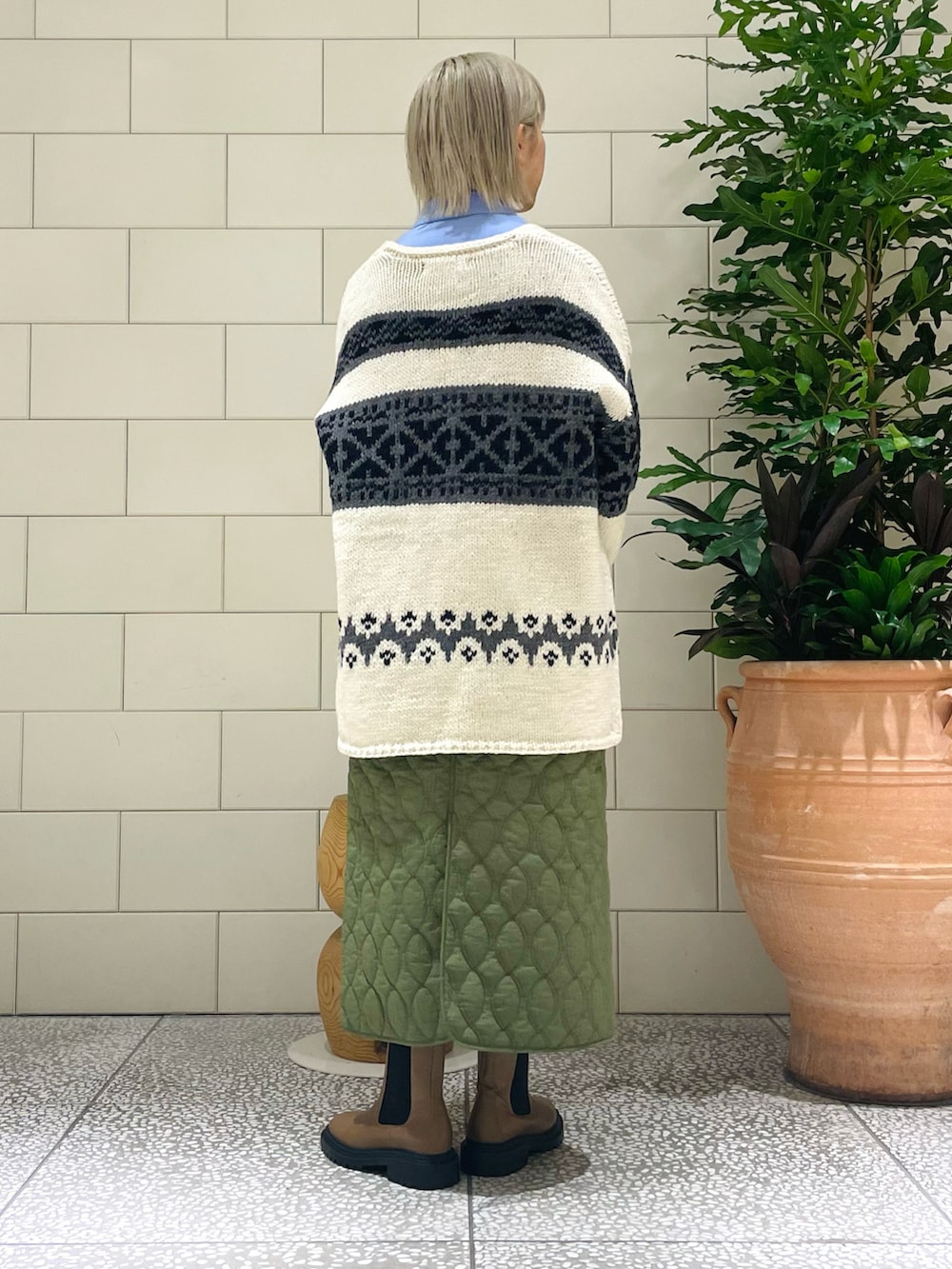 ホワイト系のカーディガン/ボレロ、ブルー系のシャツ/ブラウス、グリーン系のスカートを着用したレディースの秋コーディネートの2枚目の写真