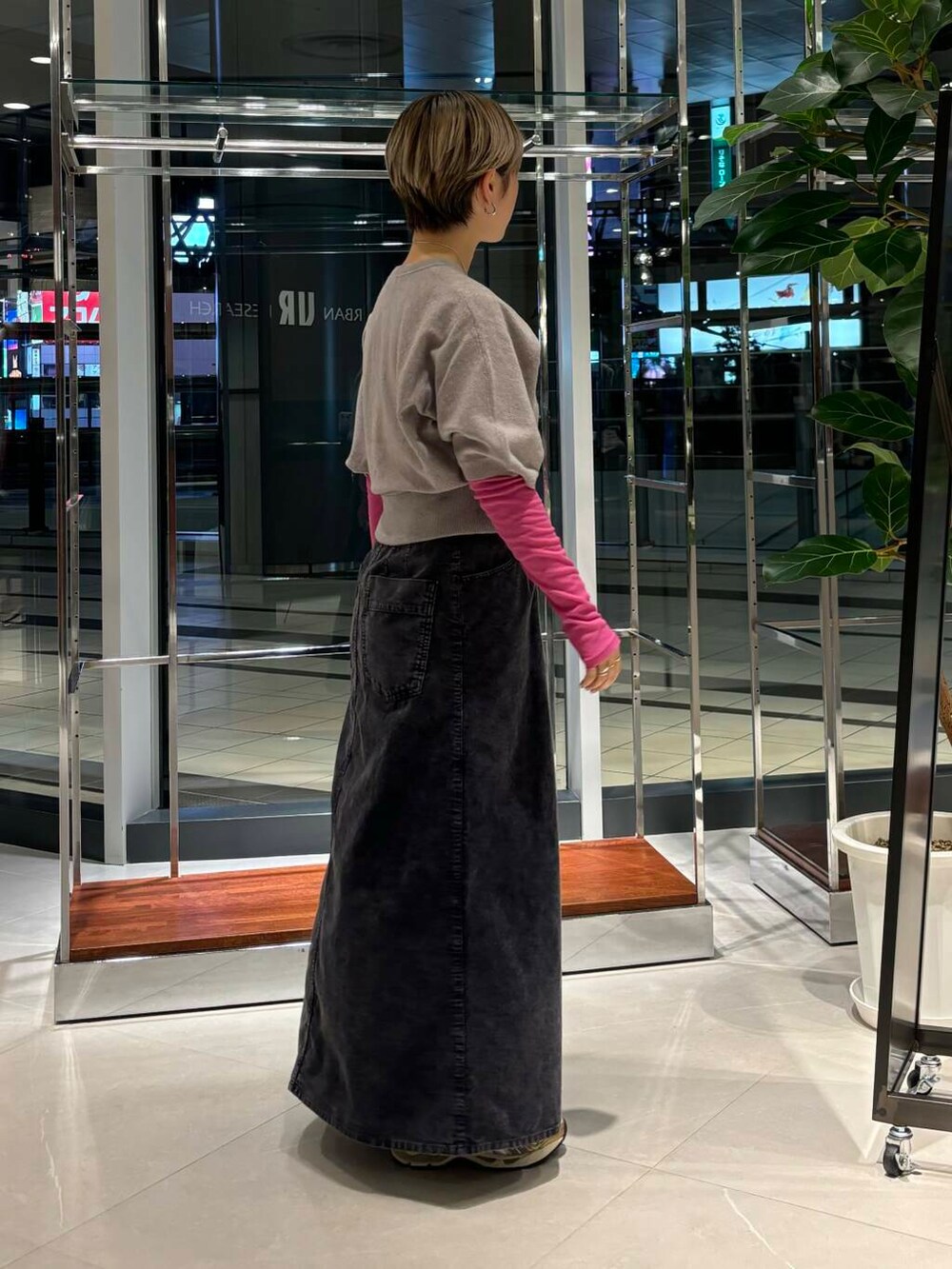 ピンク系のTシャツ/カットソー、ホワイト系のスニーカー、ブルー系のスカートを着用したレディースの秋コーディネートの2枚目の写真