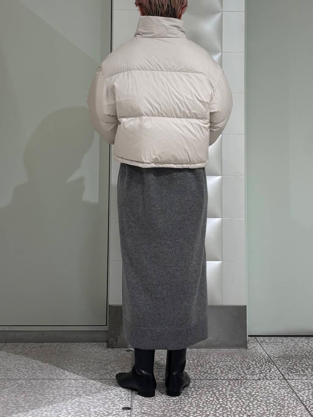 ブラック系のトートバッグ、ブラック系のブーツ、ホワイト系のダウンジャケット/コートを着用したレディースの冬コーディネートの4枚目の写真