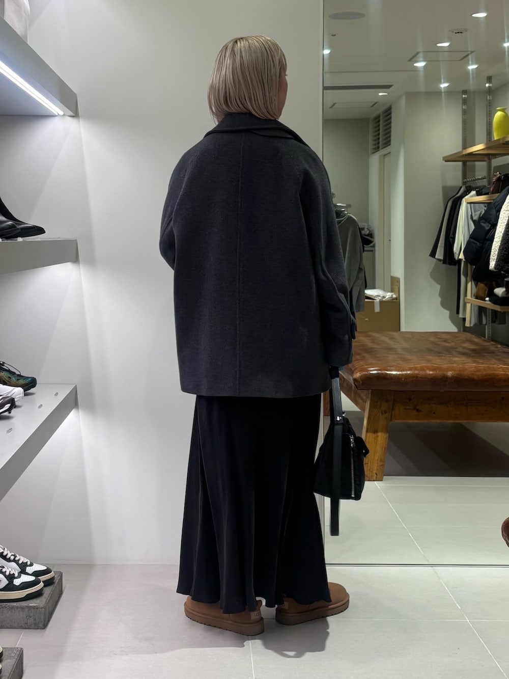 グレー系のピーコート、ブルー系のニット/セーター、ブラック系のショルダーバッグを着用したレディースの秋コーディネートの4枚目の写真