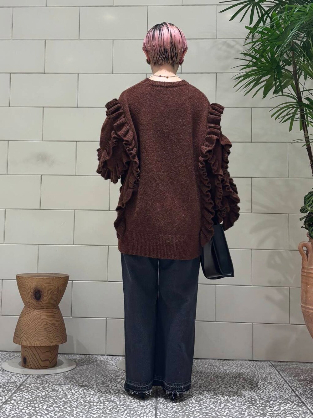 ブラック系のデニムパンツ、ブラック系のトートバッグ、ブラウン系のブーツを着用したレディースの冬コーディネートの3枚目の写真