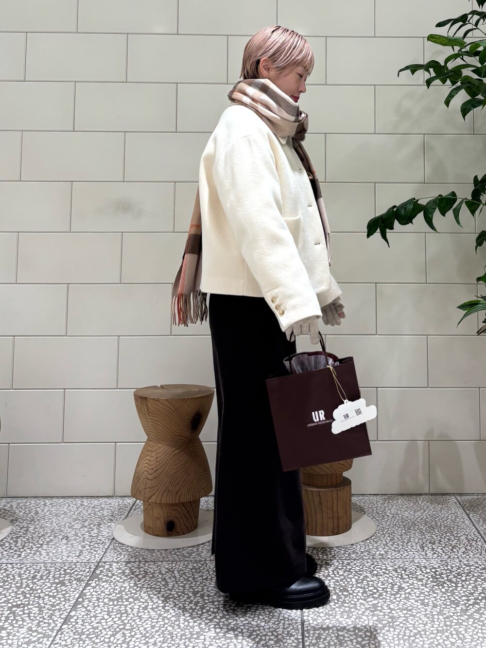 ホワイト系のその他アウター、グレー系のスカート、ブラウン系のストール/ショールを着用したレディースの冬コーディネートの3枚目の写真