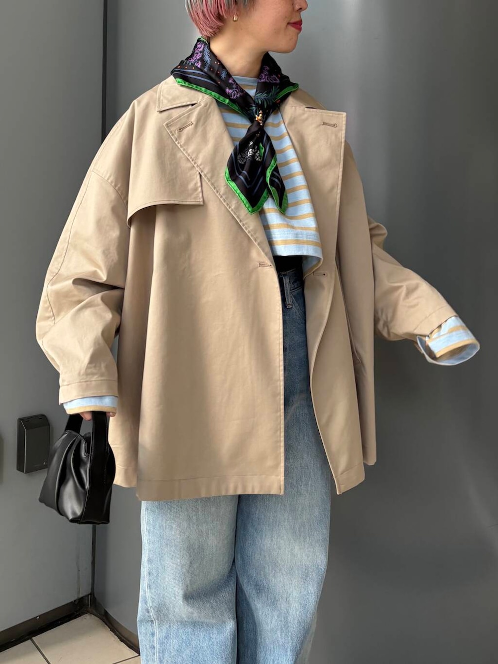 ブルー系のデニムパンツ、ベージュ系のトレンチコート、その他のTシャツ/カットソーを着用したレディースの春コーディネートの3枚目の写真
