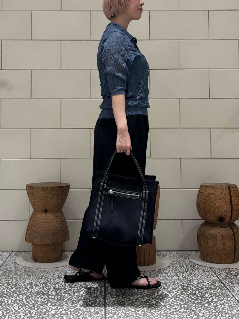 グレー系のニット/セーター、ブラック系のサンダルを着用したレディースの春コーディネートの3枚目の写真