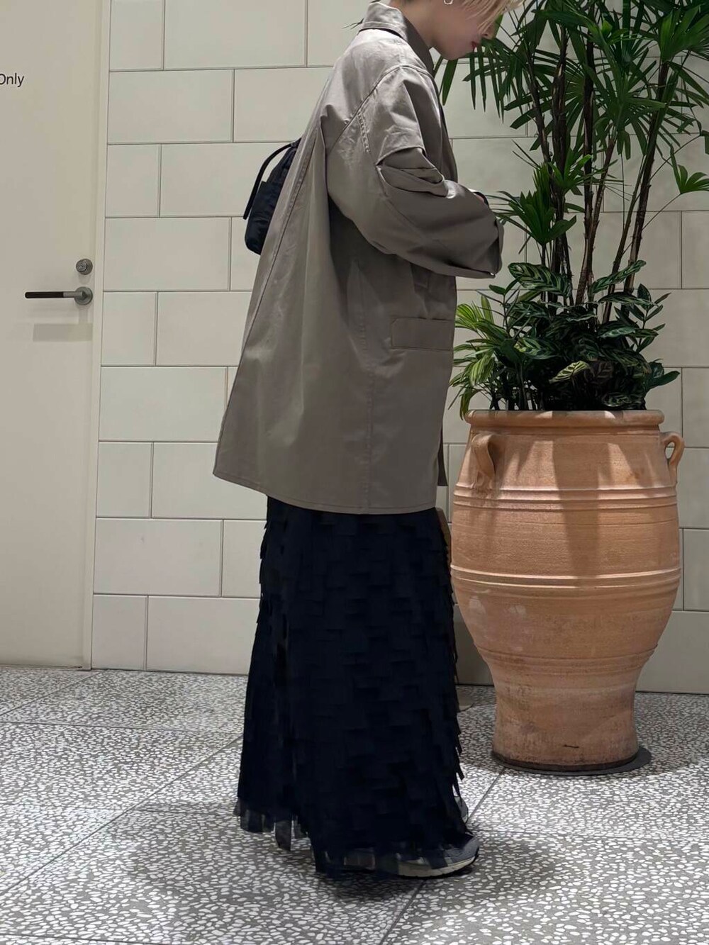 ホワイト系のスニーカー、ブラック系のショルダーバッグを着用したレディースの冬コーディネートの3枚目の写真