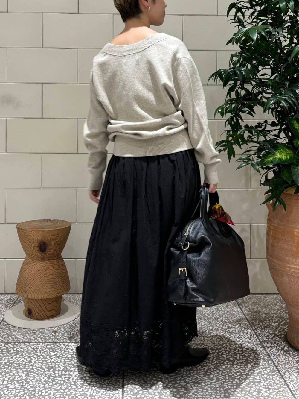 ベージュ系のニット/セーター、ブラック系のボストンバッグ、ブラック系のスカートを着用したレディースの秋コーディネートの3枚目の写真