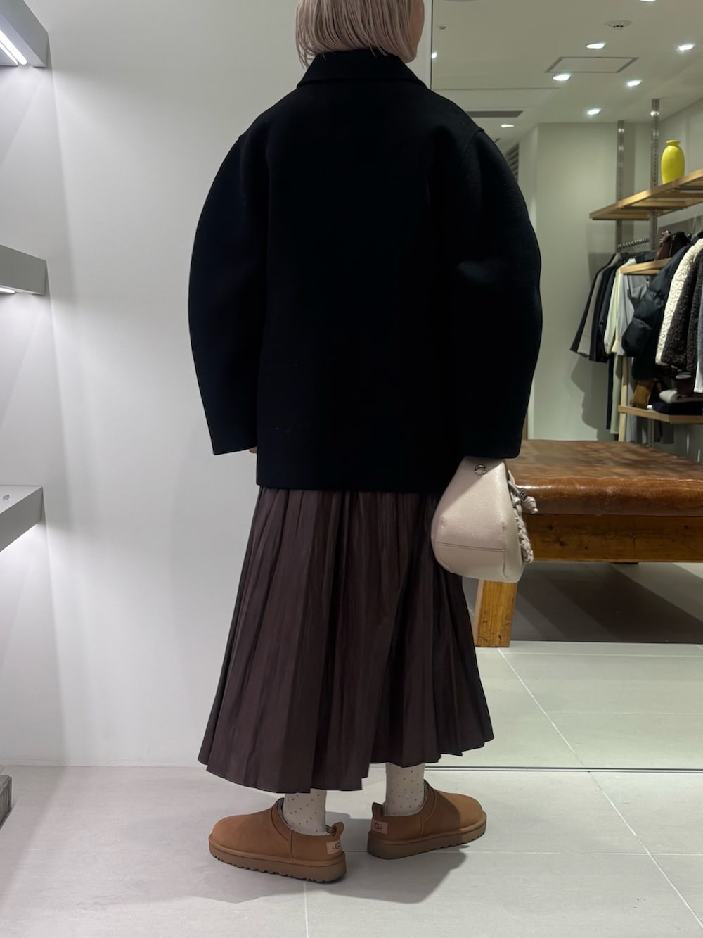 ブラック系のテーラードジャケット、グレー系のニット/セーター、ブラウン系のスカートを着用したレディースの秋コーディネートの3枚目の写真