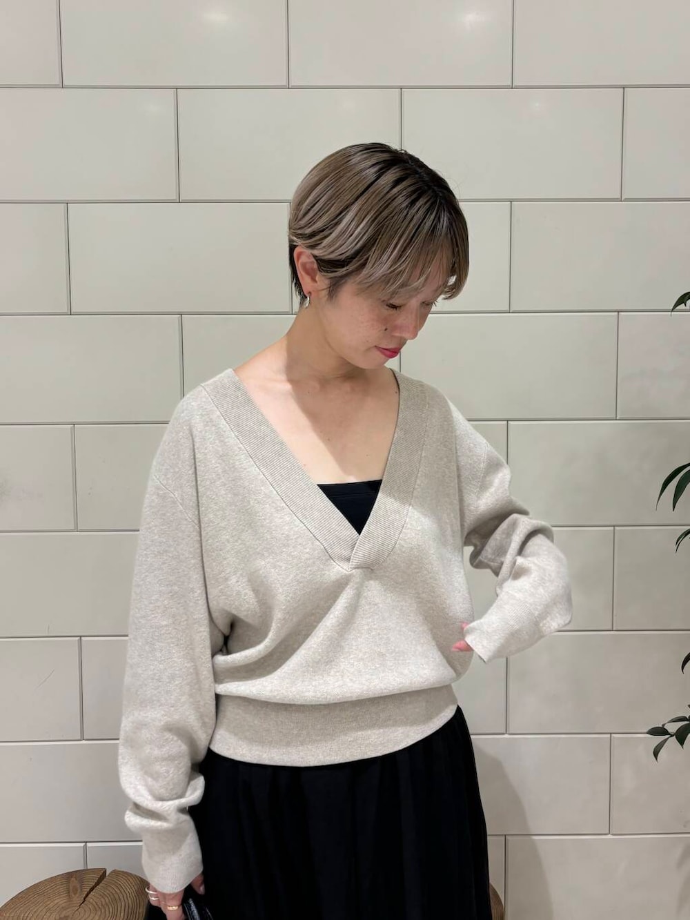 ベージュ系のニット/セーター、ブラック系のボストンバッグ、ブラック系のスカートを着用したレディースの秋コーディネートの4枚目の写真