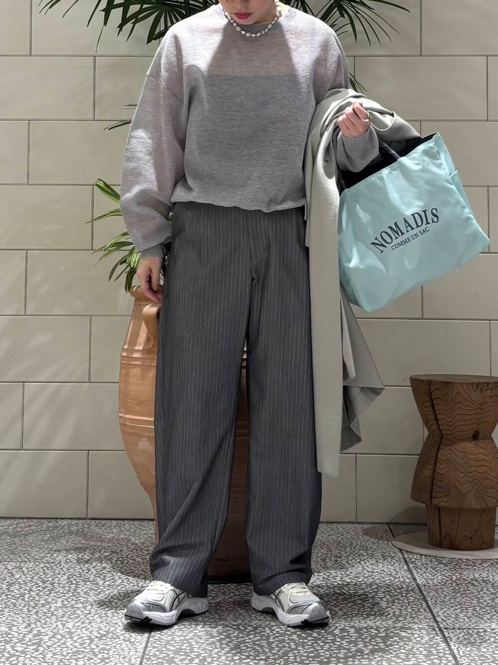 グレー系のその他パンツ、グリーン系のトレンチコート、グレー系のニット/セーターを着用したレディースの冬コーディネートの2枚目の写真