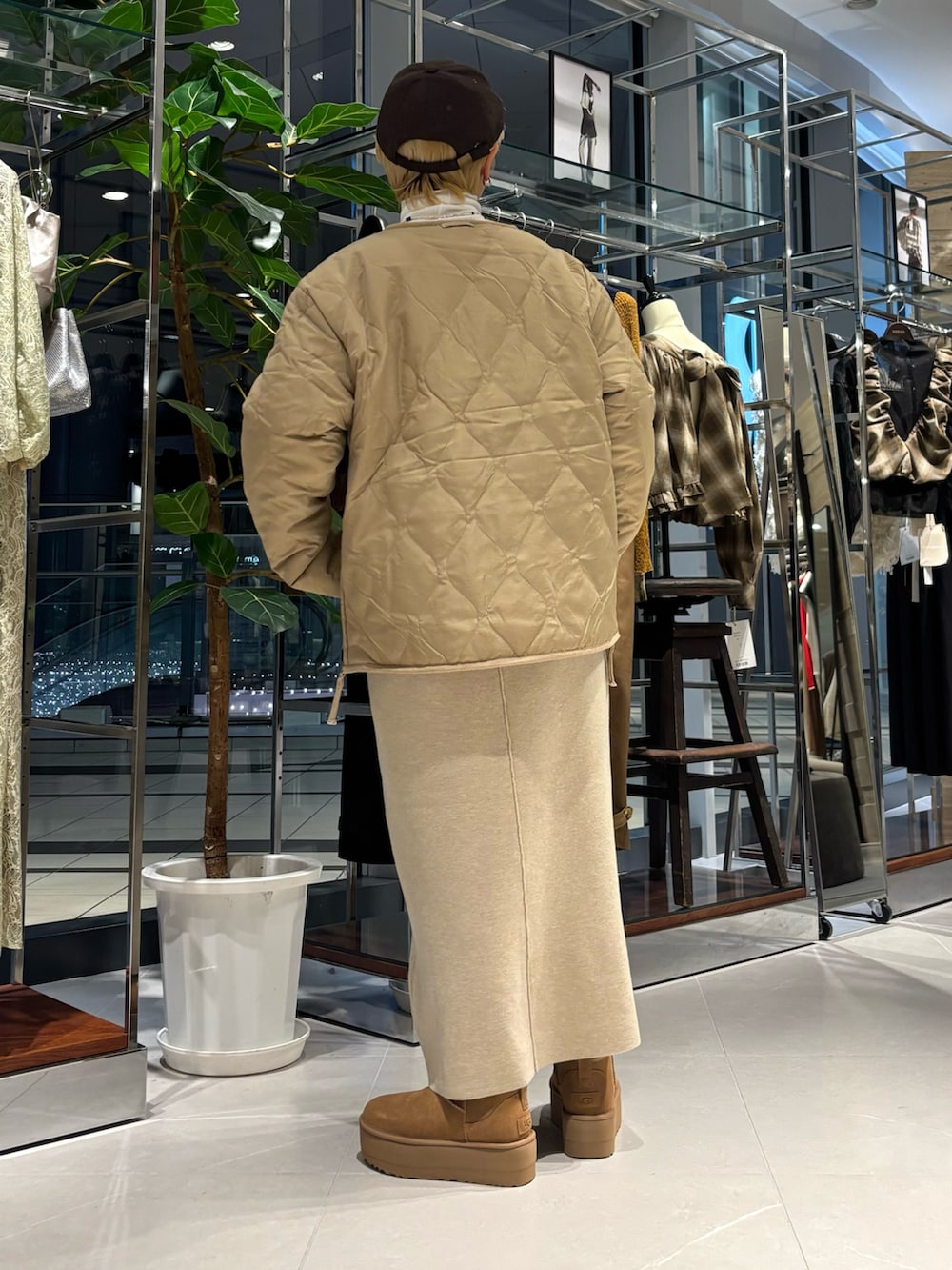 ホワイト系のTシャツ/カットソー、ベージュ系のダウンジャケット/コート、ブラウン系のブーツを着用したレディースの秋コーディネートの3枚目の写真